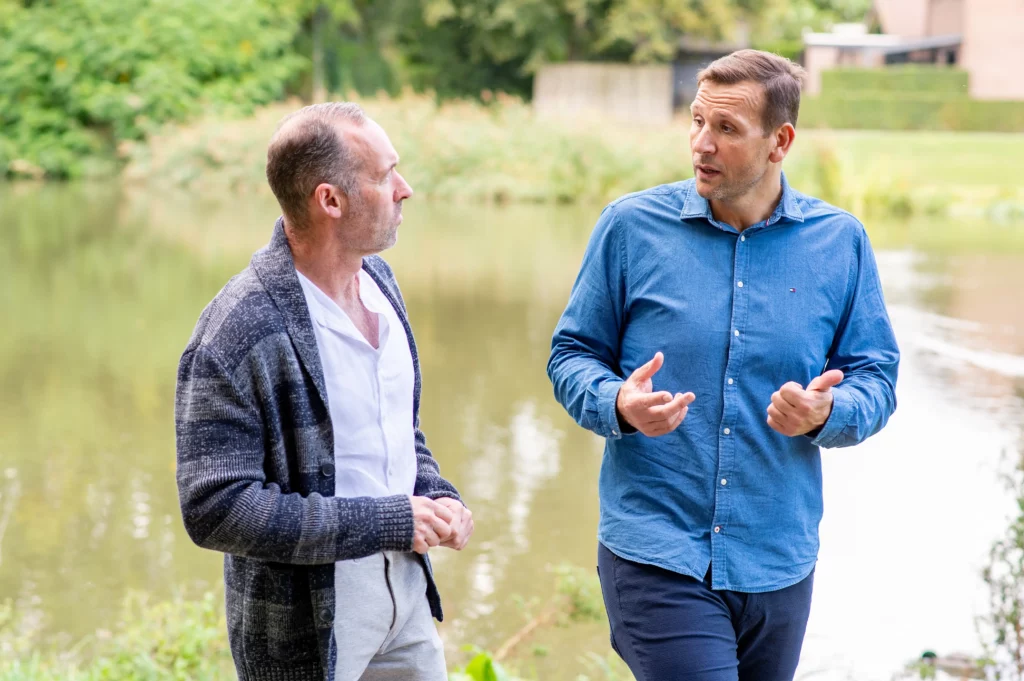 Twee mannen wandelen in de natuur die met elkaar praten