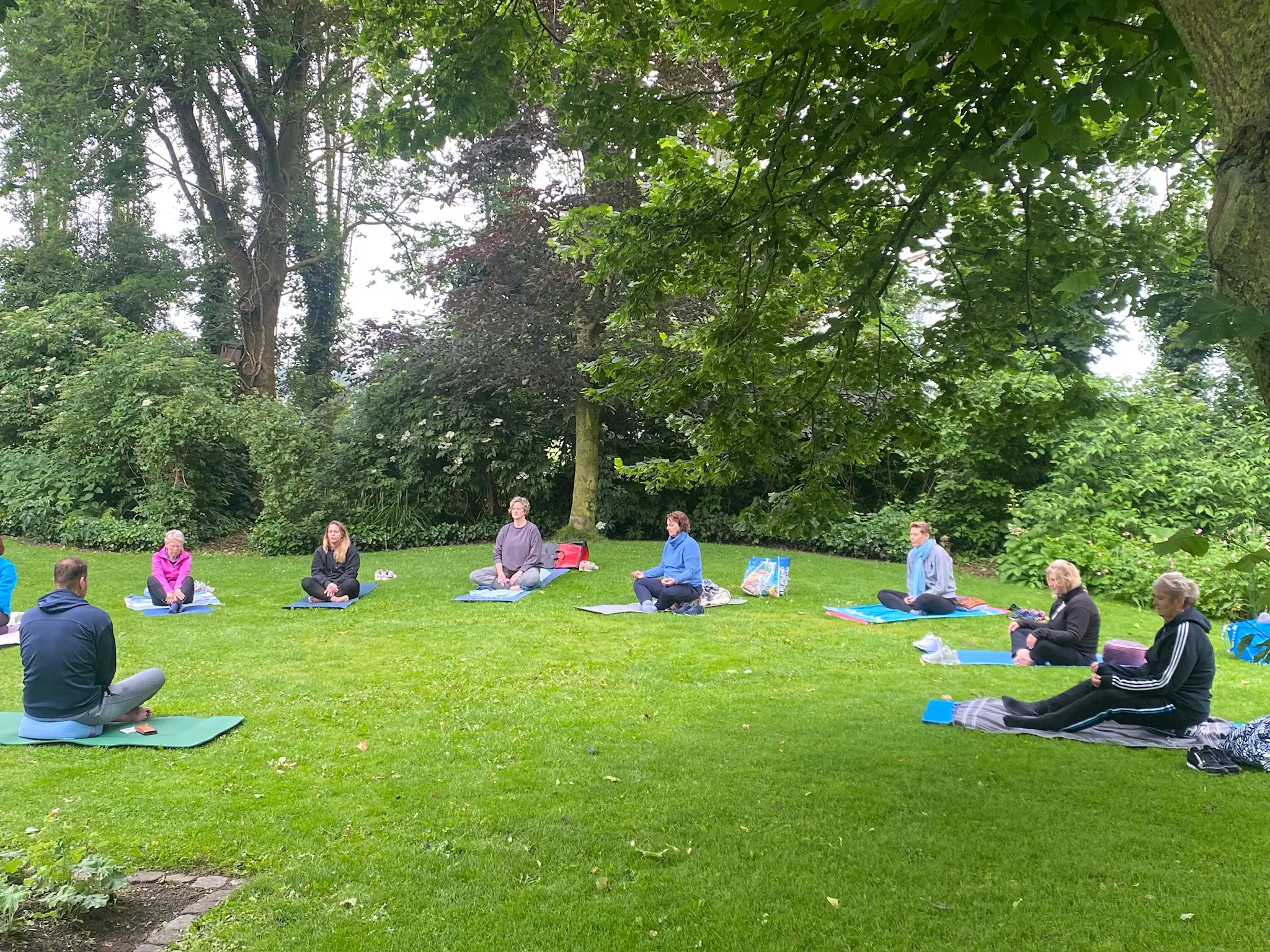 buitenyoga met een groep zittend in het gras