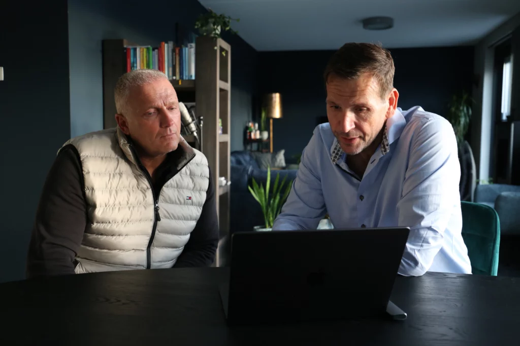 twee heren in gesprek achter een laptop